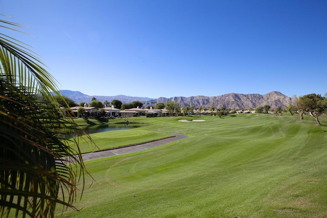 surrounding community with a yard and a water and mountain view