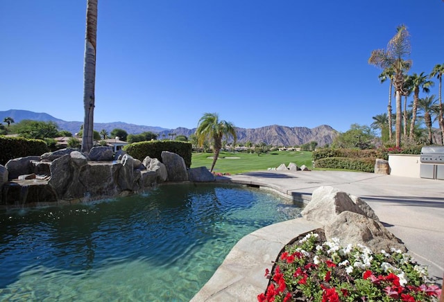 view of swimming pool with a mountain view and pool water feature