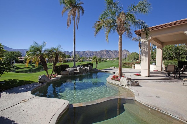 view of pool featuring a mountain view, a yard, and a patio