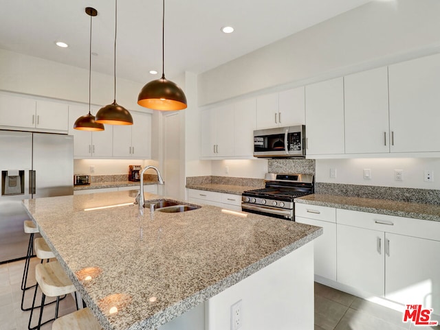 kitchen featuring appliances with stainless steel finishes, an island with sink, white cabinetry, and sink