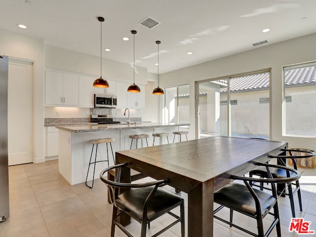 tiled dining area with a wealth of natural light and sink