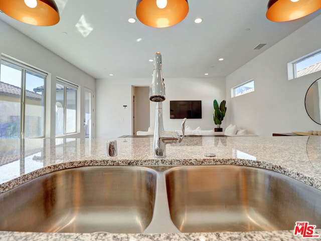 kitchen with light stone countertops and sink