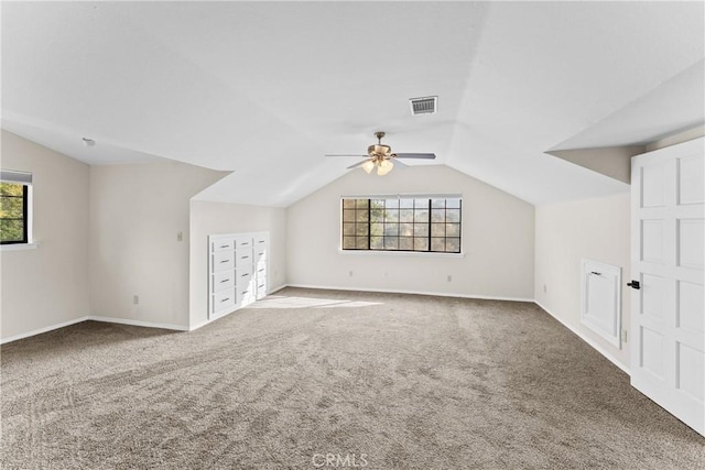 additional living space featuring carpet floors, a healthy amount of sunlight, and lofted ceiling