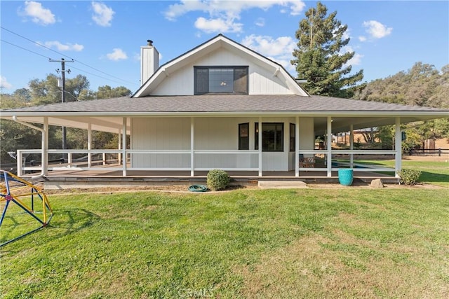 rear view of property featuring a lawn