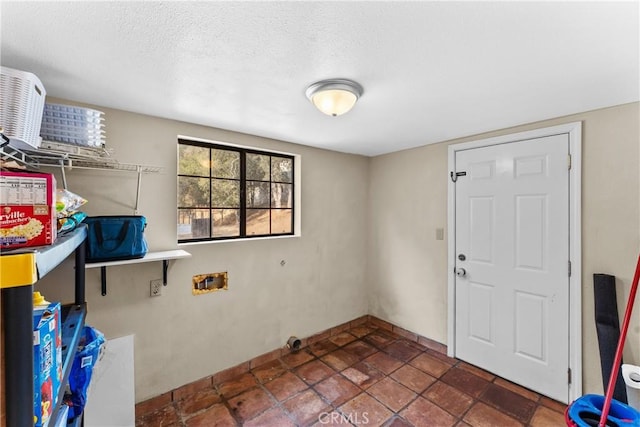 laundry room with hookup for a washing machine and a textured ceiling