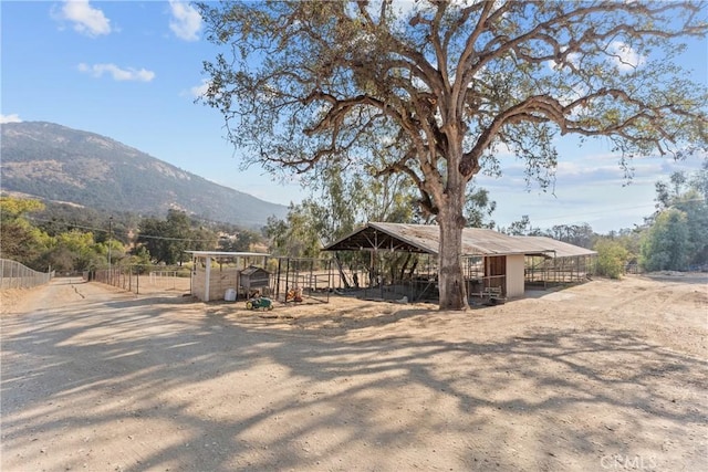 exterior space featuring a mountain view, an outbuilding, and a rural view