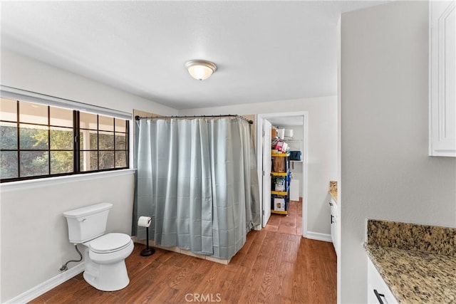 bathroom with hardwood / wood-style floors, vanity, curtained shower, and toilet