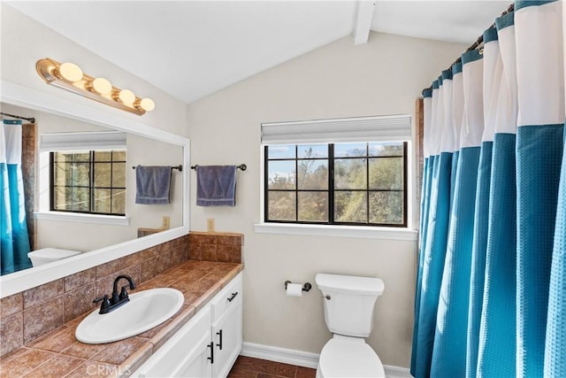 bathroom with plenty of natural light, vanity, lofted ceiling with beams, and toilet