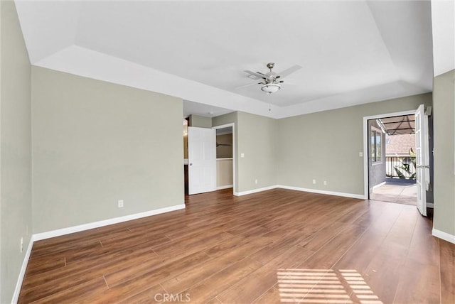 unfurnished room featuring hardwood / wood-style floors, a raised ceiling, and ceiling fan