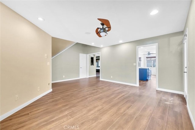 unfurnished living room featuring ceiling fan and light hardwood / wood-style flooring