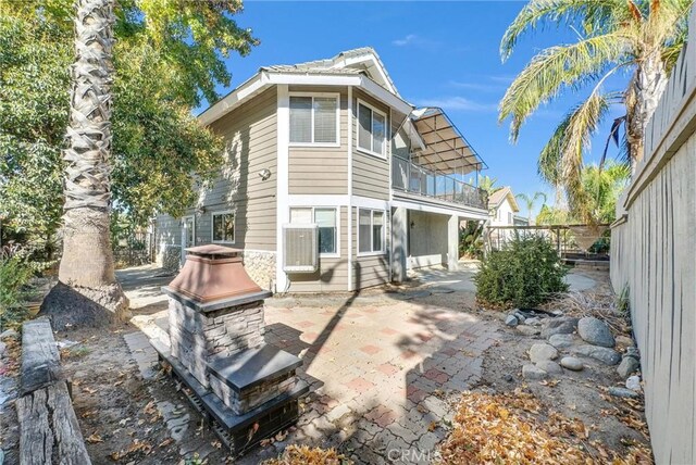 rear view of property featuring a patio area and a balcony