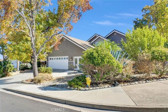 view of property hidden behind natural elements featuring a garage