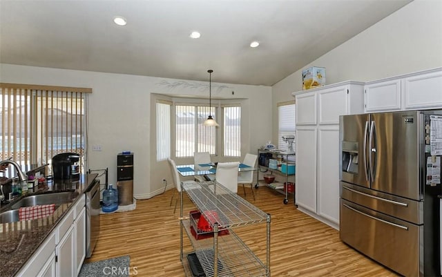 kitchen with stainless steel refrigerator with ice dispenser, sink, white cabinets, and decorative light fixtures