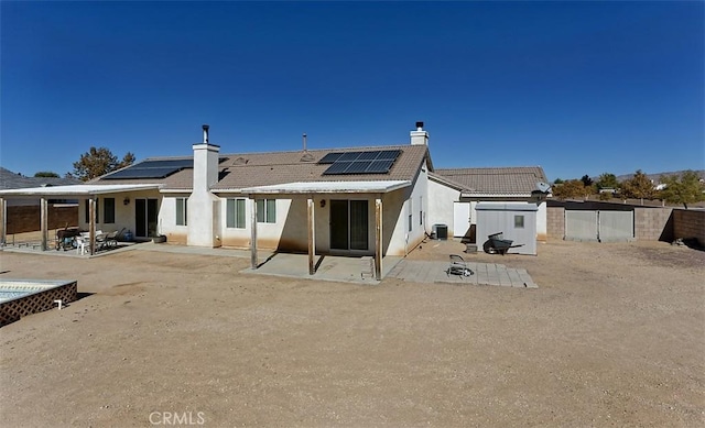 back of property featuring central AC, a patio area, and solar panels