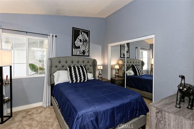 carpeted bedroom featuring vaulted ceiling and a closet