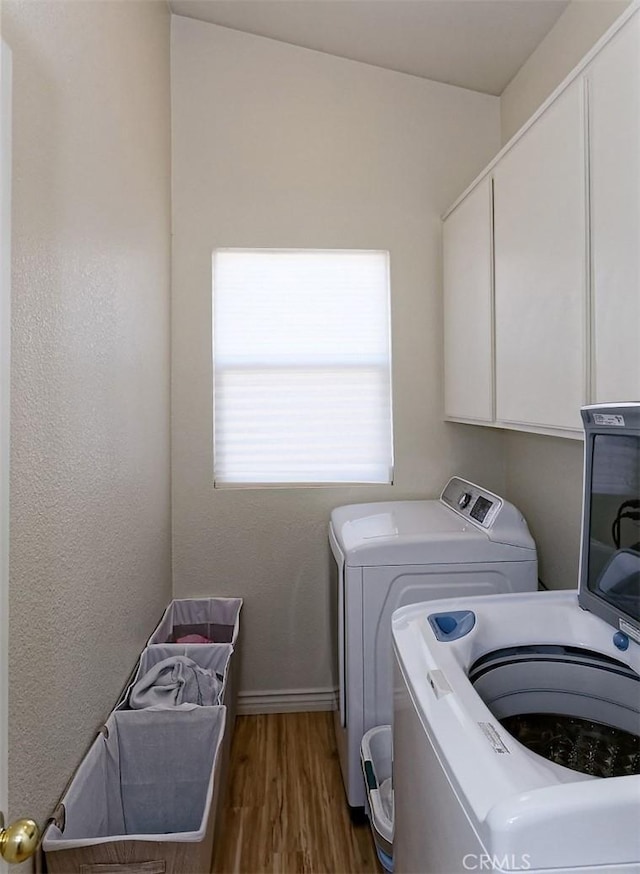 washroom featuring cabinets, dark hardwood / wood-style flooring, and washer and clothes dryer