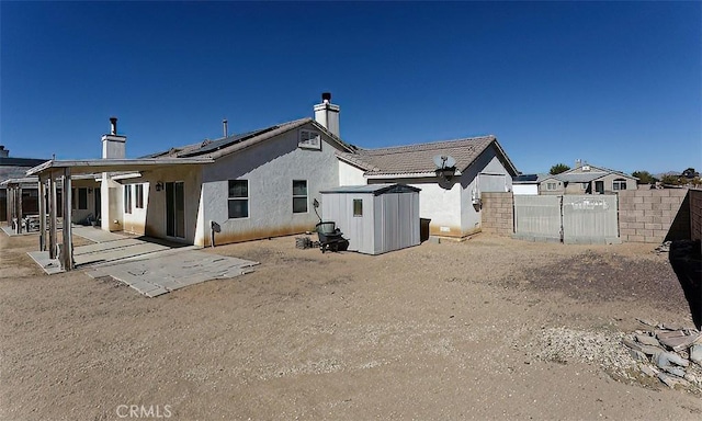 back of house with a patio and solar panels