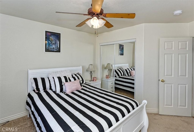 bedroom featuring light colored carpet, ceiling fan, and a closet