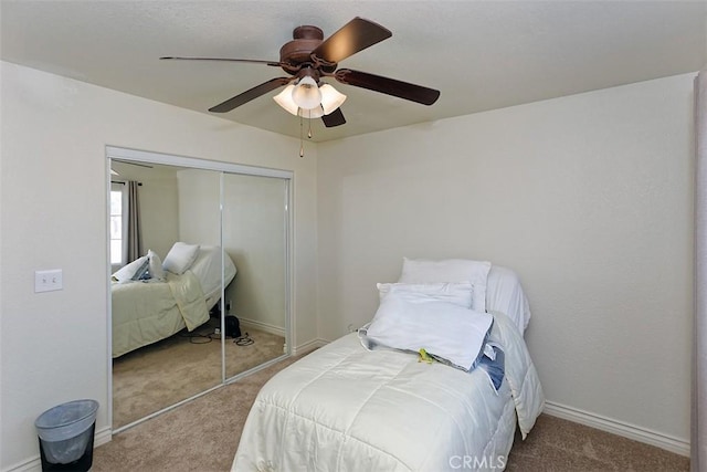 carpeted bedroom with ceiling fan and a closet