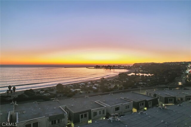 aerial view at dusk featuring a water view