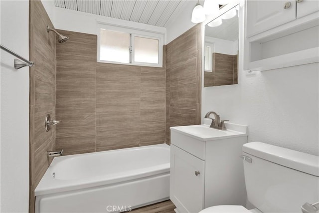 full bathroom with hardwood / wood-style floors, vanity, toilet, and tiled shower / bath