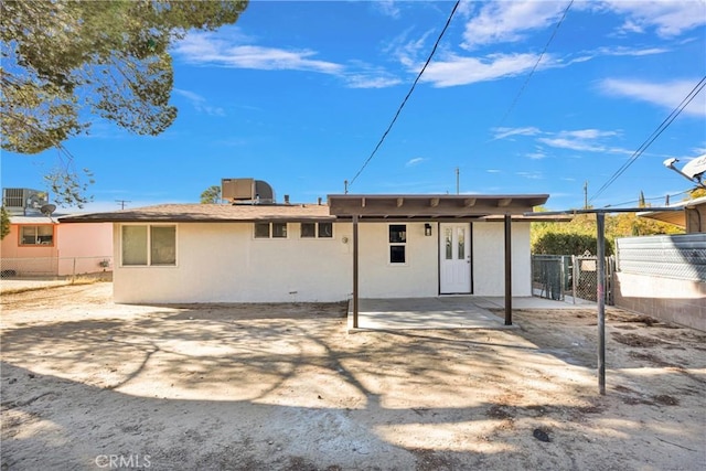 back of property with cooling unit and a patio area