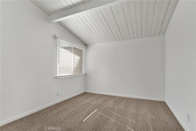 carpeted spare room with lofted ceiling with beams and baseboards