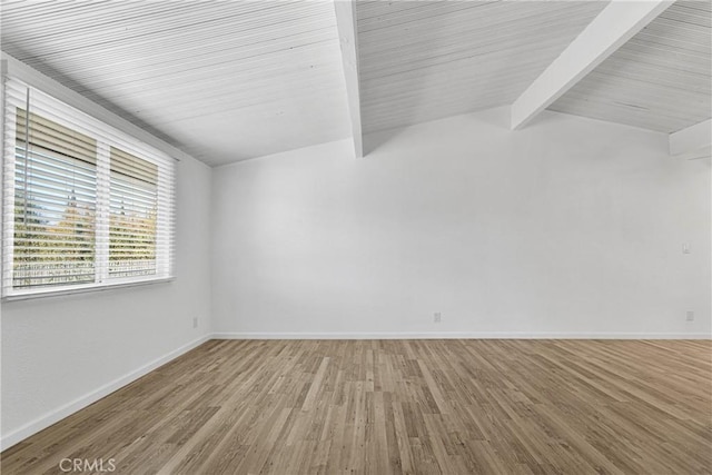 unfurnished room featuring vaulted ceiling with beams and hardwood / wood-style flooring