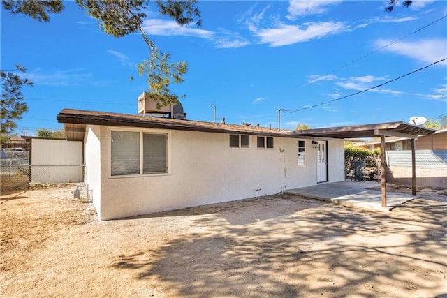 back of house with a patio area, fence, and stucco siding