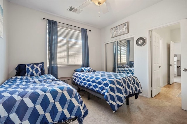 bedroom featuring a closet, light colored carpet, and ceiling fan