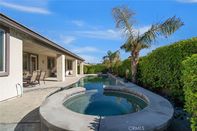 view of pool featuring a patio area and an in ground hot tub