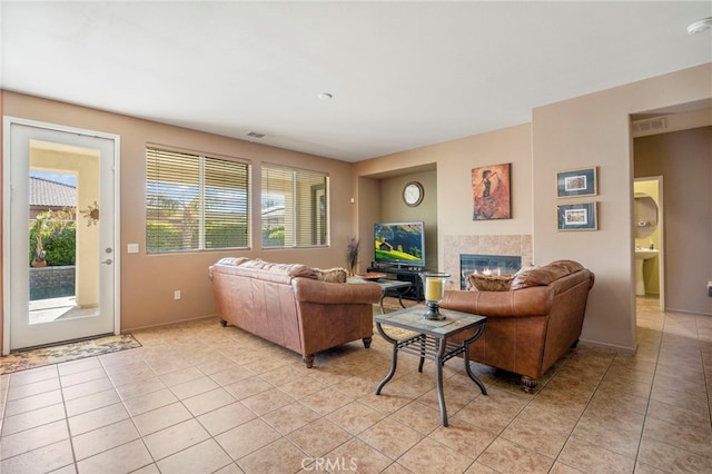 living room with sink, light tile patterned flooring, and a healthy amount of sunlight