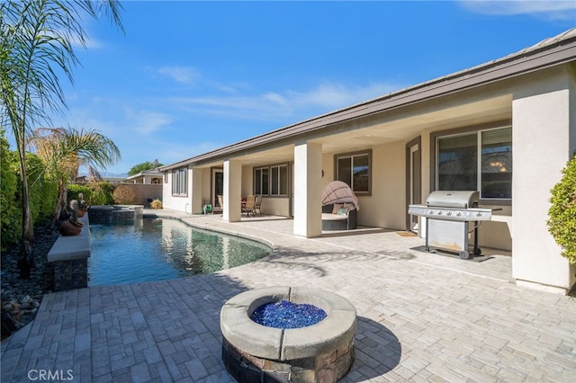 view of pool featuring an in ground hot tub, a patio, an outdoor fire pit, and a grill