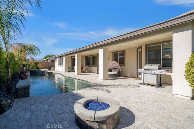 view of swimming pool featuring a fenced in pool, an outdoor fire pit, a patio area, a grill, and an in ground hot tub