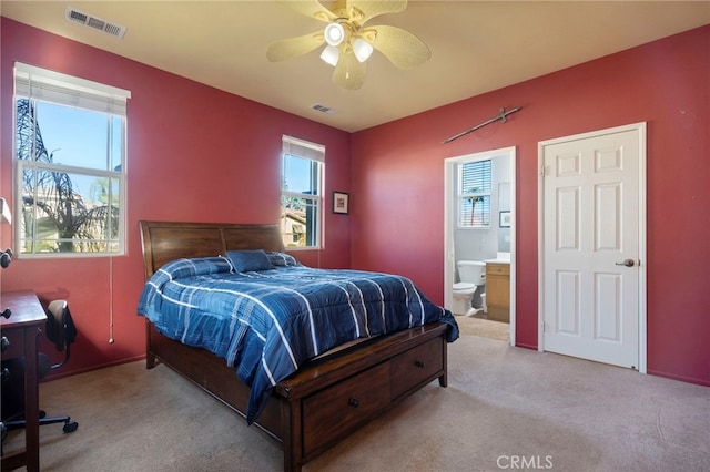 carpeted bedroom featuring connected bathroom and ceiling fan