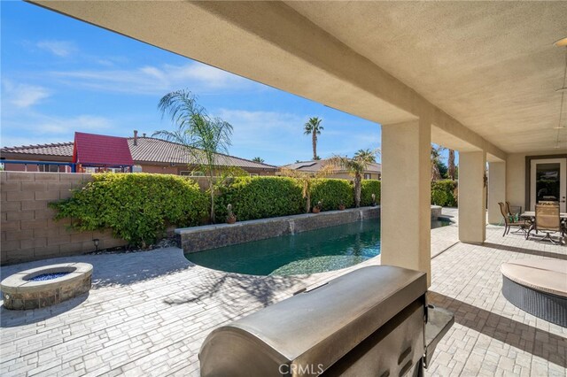 view of swimming pool with a patio area and an outdoor fire pit