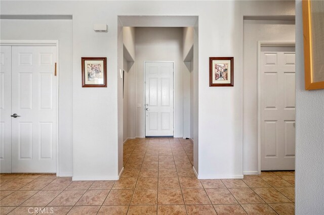 hallway with light tile patterned flooring and baseboards