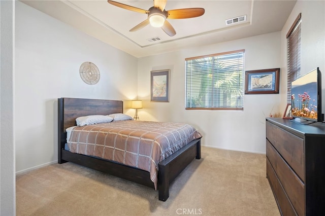 bedroom featuring visible vents, light colored carpet, baseboards, and ceiling fan