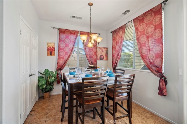 tiled dining room featuring visible vents, baseboards, and an inviting chandelier