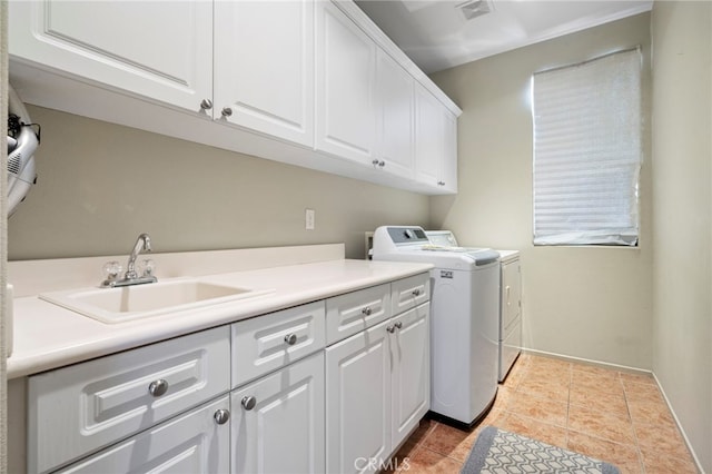 washroom featuring visible vents, cabinet space, a sink, tile patterned floors, and washer and clothes dryer