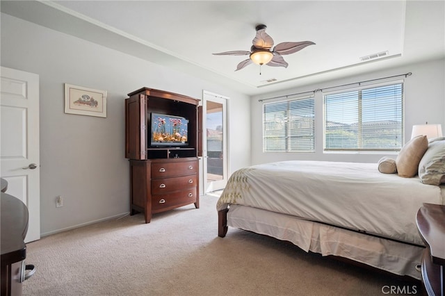 bedroom with visible vents, light carpet, a ceiling fan, and ensuite bathroom
