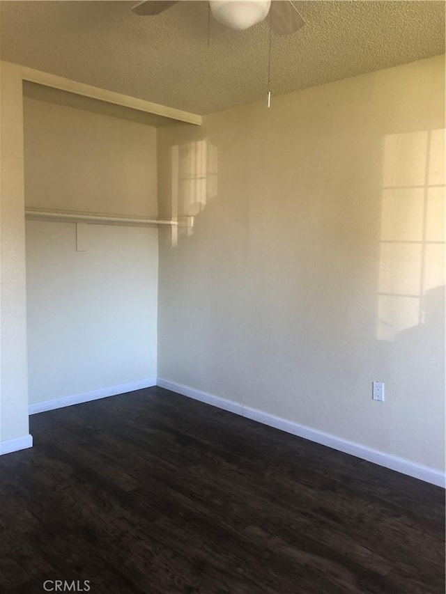 unfurnished room featuring dark hardwood / wood-style floors, ceiling fan, and a textured ceiling