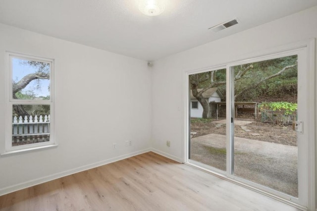 unfurnished room featuring light hardwood / wood-style floors and a healthy amount of sunlight