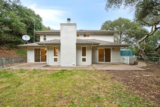 rear view of property with a yard and a patio