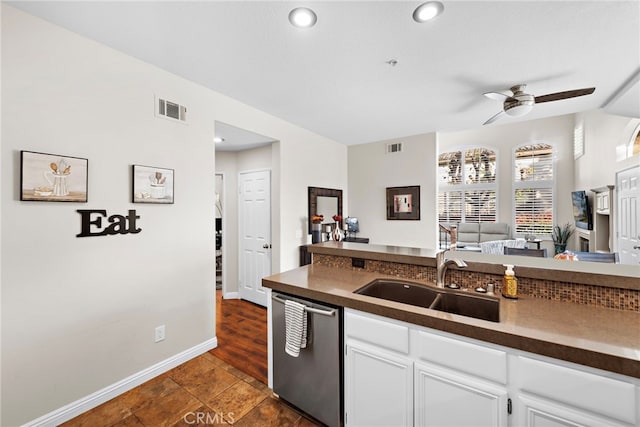 kitchen featuring a ceiling fan, visible vents, a sink, stainless steel dishwasher, and dark countertops