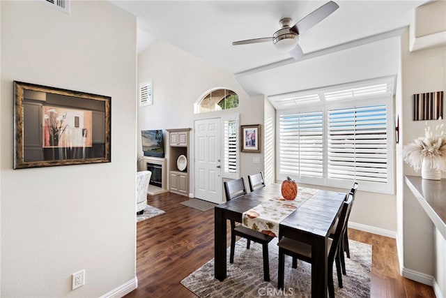 dining room with ceiling fan, vaulted ceiling, and dark hardwood / wood-style floors