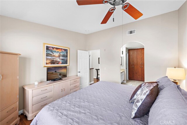 bedroom with ensuite bathroom, a high ceiling, and ceiling fan