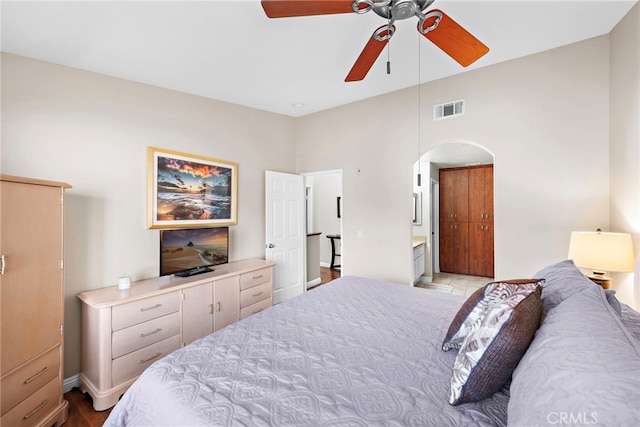 bedroom featuring arched walkways, visible vents, and ceiling fan