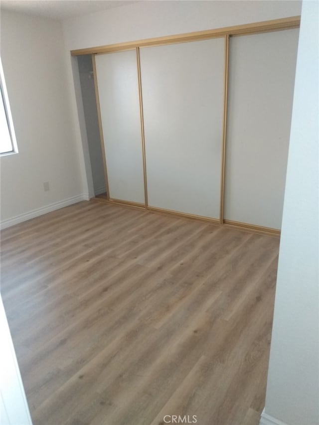 unfurnished bedroom featuring hardwood / wood-style flooring and a closet