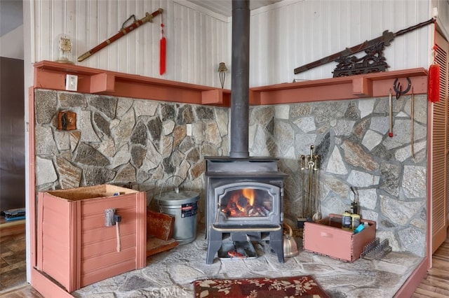 interior details with hardwood / wood-style floors, a wood stove, and wooden walls